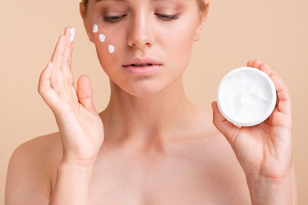 woman-applying-face-cream face cream jars