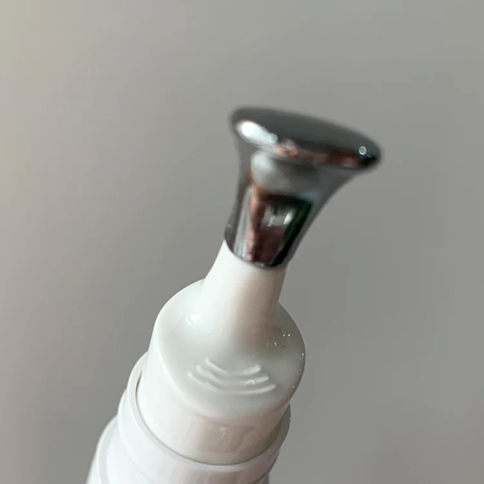 white cosmetic eye serum cream bottle with metal head