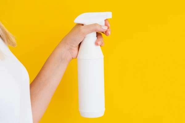 holding a white trigger spray bottle